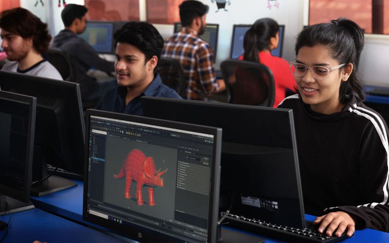 A diverse group of students focused on their computer screens, engaged in collaborative work.